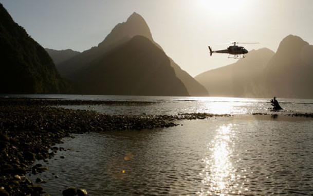 Helicopter flying in the distance with mountains in the background