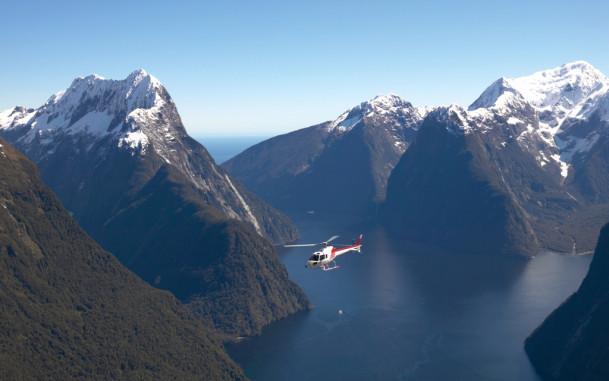 Helicopter flying in the distance surrounded by mountains