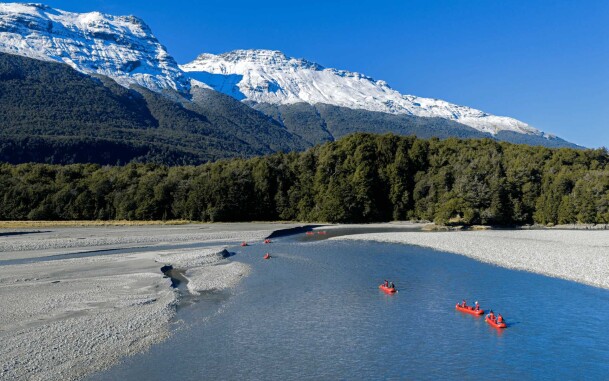 Aerial view of funyaks paddling down the Dart River, surrounded by dramatic mountain scenery.
