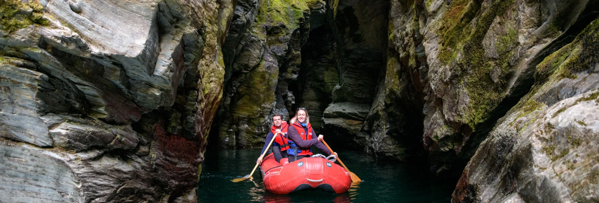 Couple paddling inflatable Funyaks on the Dart River through the hidden chasms