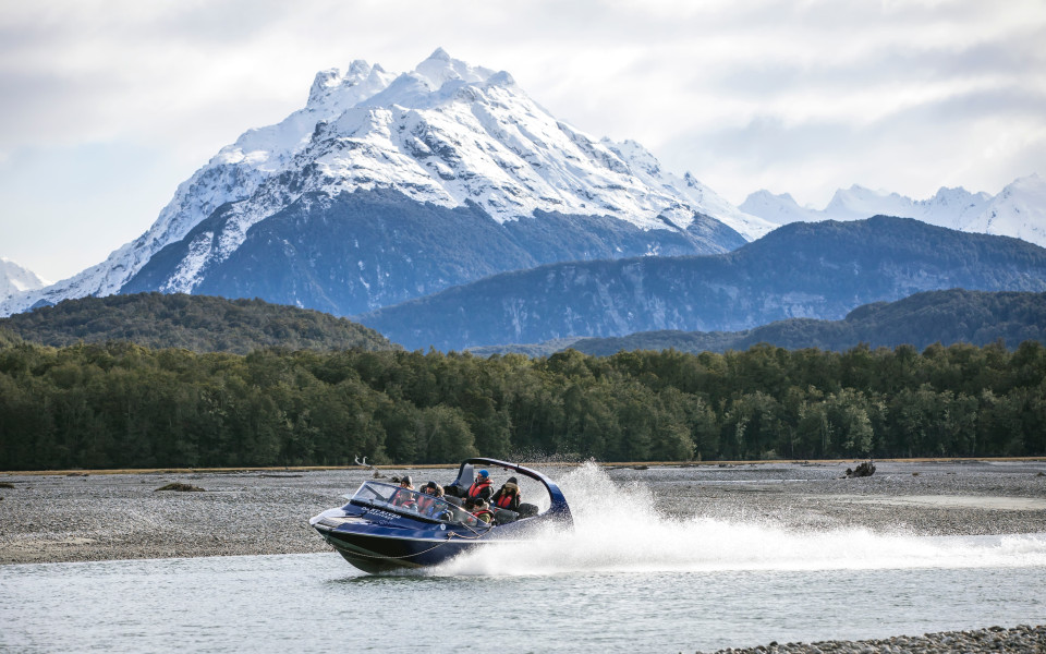 The Dart River Wilderness Jet, with the impressive background of Mt Aspiring National Park 