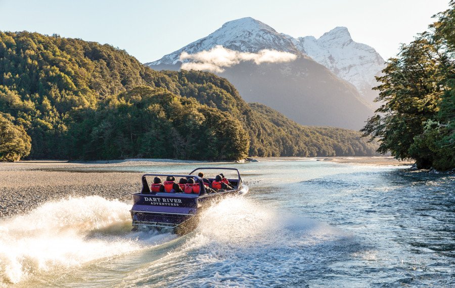 Jet boat travelling up river towards mountains 